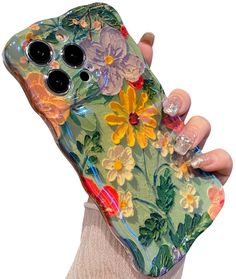 a woman holding up a phone case with flowers on the front and sides, in her right hand