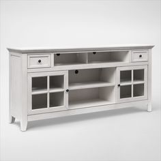 a white entertainment center with glass doors and drawers on one side, in front of a plain background