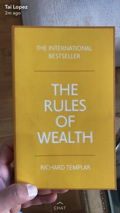 a person holding up a yellow book with the title'the rules of health '