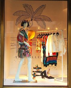 a window display with clothes and shoes on mannequins