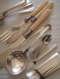 an assortment of silverware including spoons and forks