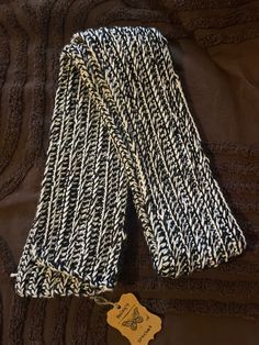 a pair of black and white knitted gloves with a tag on the bottom of it