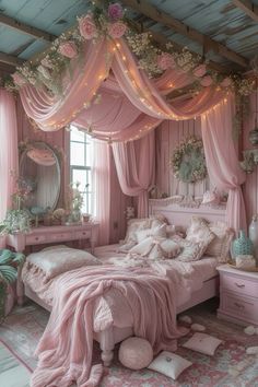 a bedroom decorated in pink and white with flowers on the ceiling, bed canopy, dressers and mirror