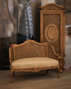 an antique chair and armoire in front of a painting