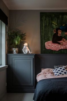 a bedroom with a painting on the wall next to a bed