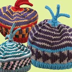 three knitted hats are shown in different colors