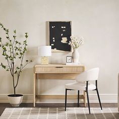 a white chair sitting in front of a wooden desk next to a potted plant