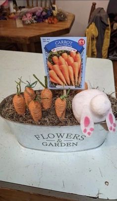 an arrangement of carrots in a flower pot with bunny ears on the side and a sign that says flowers garden