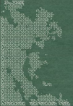 a green rug with an intricate design on the front and back side, in white