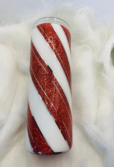 a red and white striped glass with glitter on it