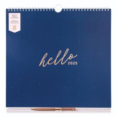 a calendar with the word hello on it and a gold pen in front of it