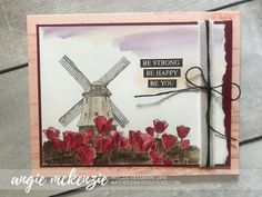 a card with red flowers and a windmill on the front that says be strong be happy be you