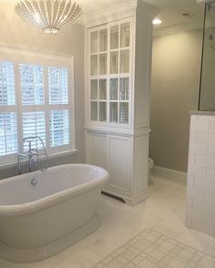 a large white bath tub sitting in a bathroom next to a walk - in shower