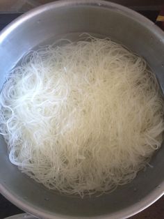 noodles are being cooked in a pot on the stove top, ready to be cooked