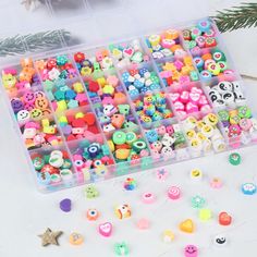 a plastic container filled with lots of different colored beads and decorations on top of a table