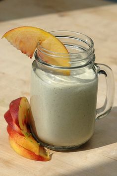 a glass jar filled with yogurt next to an apple