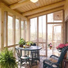 a screened porch with wicker furniture and potted plants