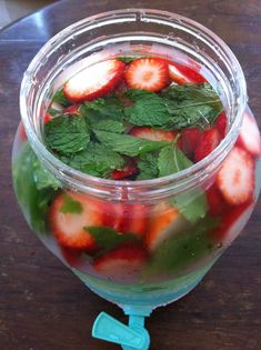 a jar filled with water and strawberries on top of a table