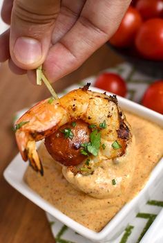 a person dipping some food into a bowl