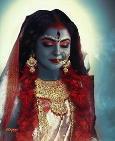 a woman with makeup and jewelry on her face, dressed in white and red attire