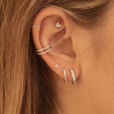 a close up of a person's ear with three different types of piercings