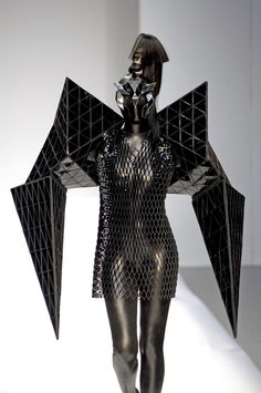 a woman is walking down the runway in a bodysuit with wings on her head