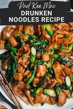 a white plate topped with stir fried noodles and veggies next to chopsticks