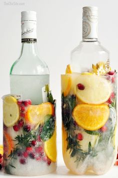 two glasses filled with fruit and ice sitting next to each other