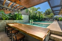 a wooden table sitting next to a swimming pool