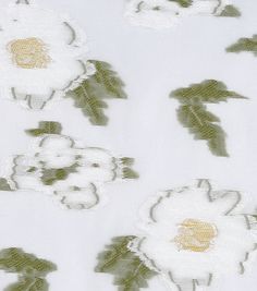 white and green flowers with leaves on a white fabric background that is very close to the ground