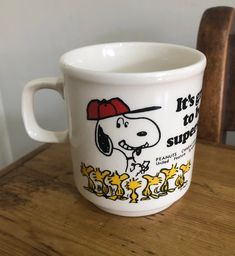 there is a coffee cup that has a snoopy dog on it, and the words let's go to school