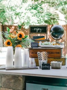 a table topped with lots of books and vases filled with flowers on top of it