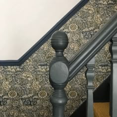 an image of a stair case with floral wallpaper