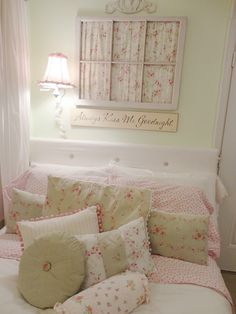 a bed with pink and white pillows on top of it