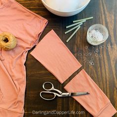 sewing supplies laid out on a table with yarn, scissors and spools next to it