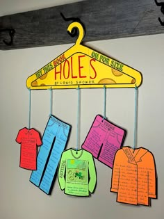 a bulletin board with clothes hanging from it's hooks and the words holes on them