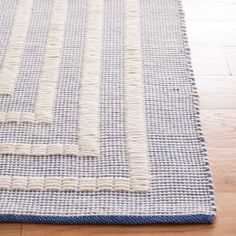 a blue and white rug on top of a wooden floor