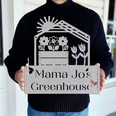 a man holding up a sign that says mama jo's greenhouse