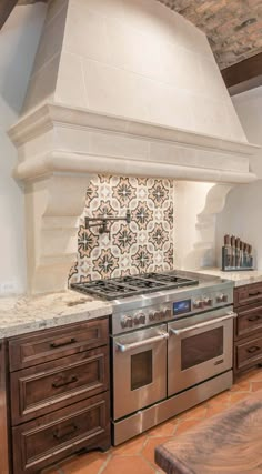 a stove top oven sitting inside of a kitchen next to wooden cabinets and counter tops