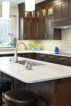 a kitchen with an island and stools next to the counter top in front of a window