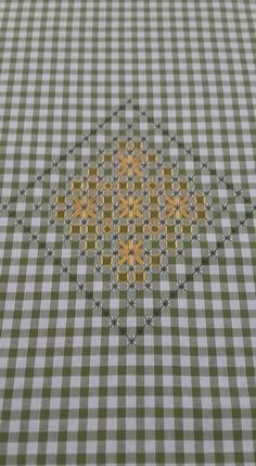 a checkered tablecloth with an intricate design on it's edges and yellow circles in the center