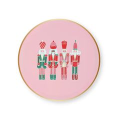 a pink plate with three nutcrackers in red and green on the front