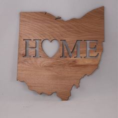 a wooden state shape with the word home carved into it's center and heart