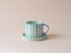 a blue and white striped cup sitting on top of a table