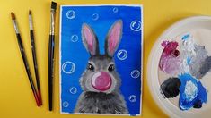 an art project with paint and watercolors on it, including a painting of a rabbit