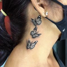 a woman's back neck with three butterflies on her left side behind the ear