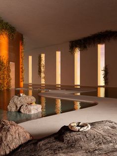 an indoor swimming pool surrounded by rocks and plants