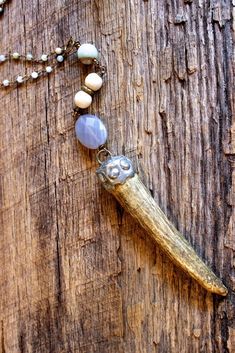 a necklace with beads and an animal's head hanging from it on a wooden surface