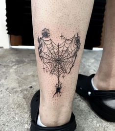 a spider web tattoo on the leg