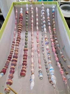 an open box filled with lots of different types of beads hanging from it's sides